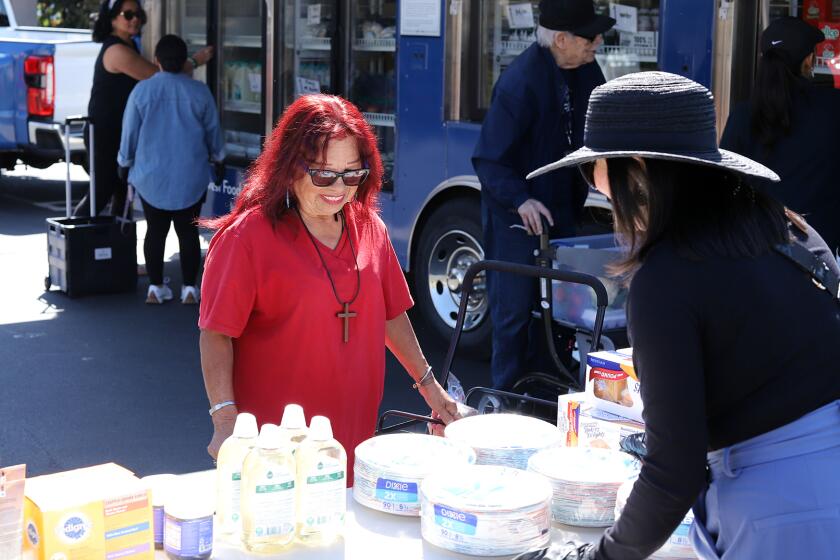 Gilda Miranda, 72, is all smiles as she picks food from the Second Harvest Food Bank "Granny's Market" a park-it-market at Villa Anaheim Senior Apartments in Anaheim on Tuesday, April 2, 2024. The massive mobile walk-up market is housed in refrigerator for seniors to select fresh dairy, eggs, protein and produce all free of charge. (Photo by James Carbone)