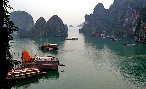The cruise ship Dragon's Pearl, foreground, is docked in northern Vietnam's Ha Long Bay, which leads to the open waters of the Gulf of Tonkin. The often mist-shrouded limestone cliffs frame the bay. A side trip on a Vietnam tour, the bay cruise consisted of three days of swimming, kayaking and just chilling on the deck of the ship, an ironwood-tooled vessel fashioned to look like a junk. Passengers were seeking respite from the motocross traffic, swarming pineapple vendors and ceaseless capitalist hustle of nearby Hanoi, Vietnam's second-largest city.