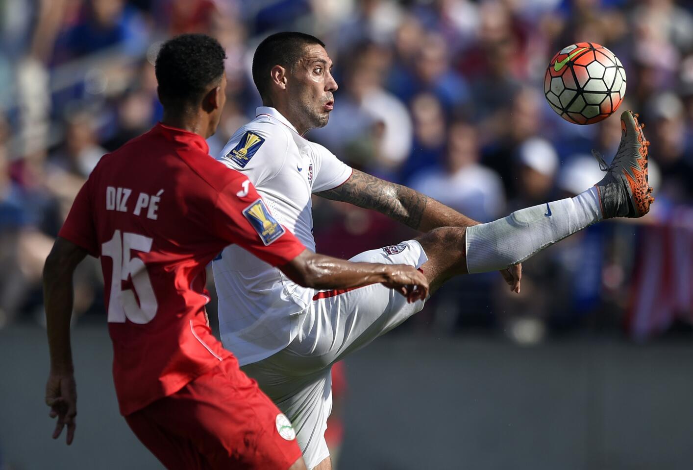 United States forward Clint Dempsey, right, kicks the ball against Cuba's Adrian Diz Pe (15) during the first half of a CONCACAF Gold Cup soccer quarterfinal match, Saturday, July 18, 2015, in Baltimore.