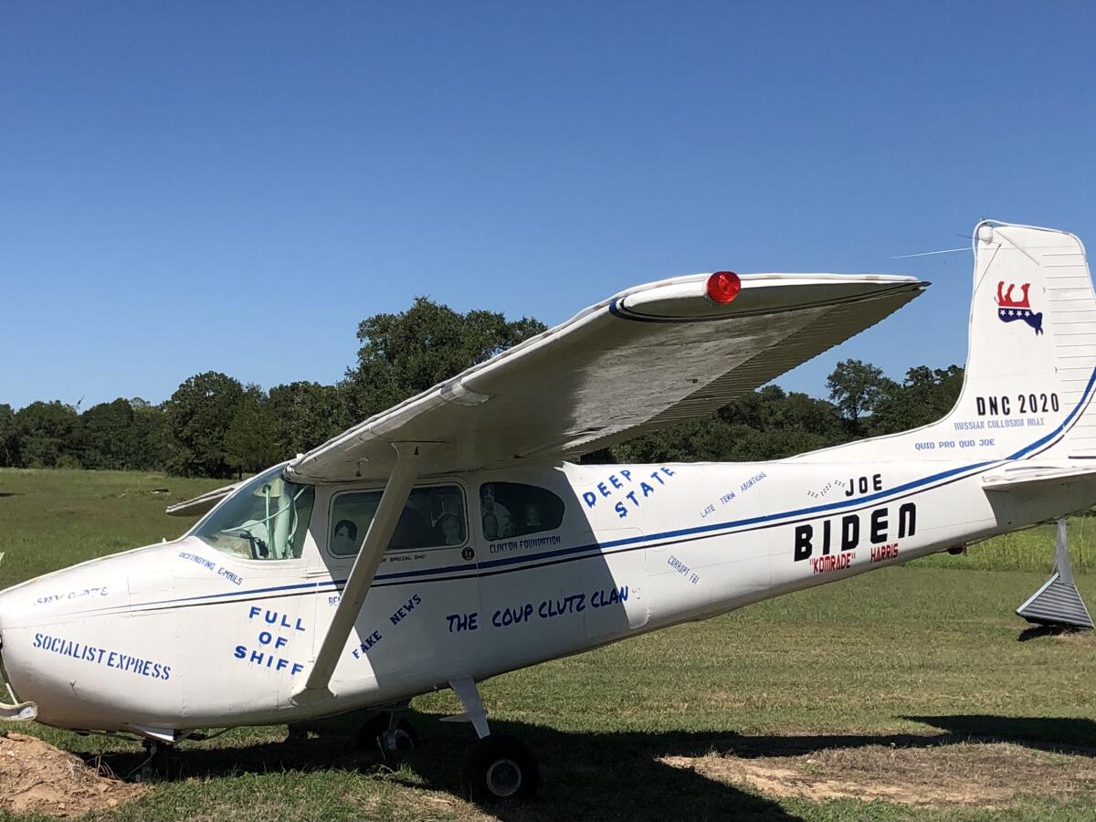 A white plane painted with Joe Biden's name and attacks on Democrats is positioned as if it nose-dived into a field in Texas.