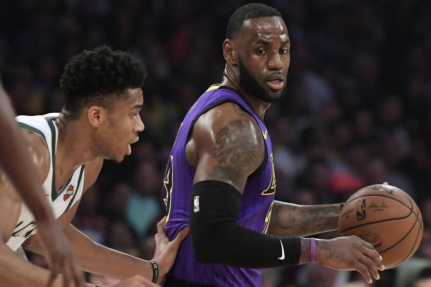 Los Angeles Lakers forward LeBron James, right, tries to move past Milwaukee Bucks forward Giannis Antetokounmpo during the first half of an NBA basketball game Friday, March 1, 2019, in Los Angeles. (AP Photo/Mark J. Terrill)