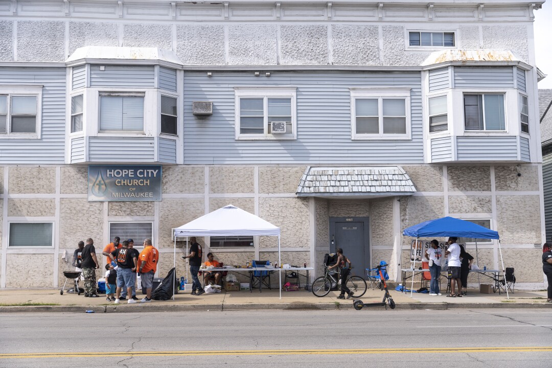 Tents and people are seen at a block party