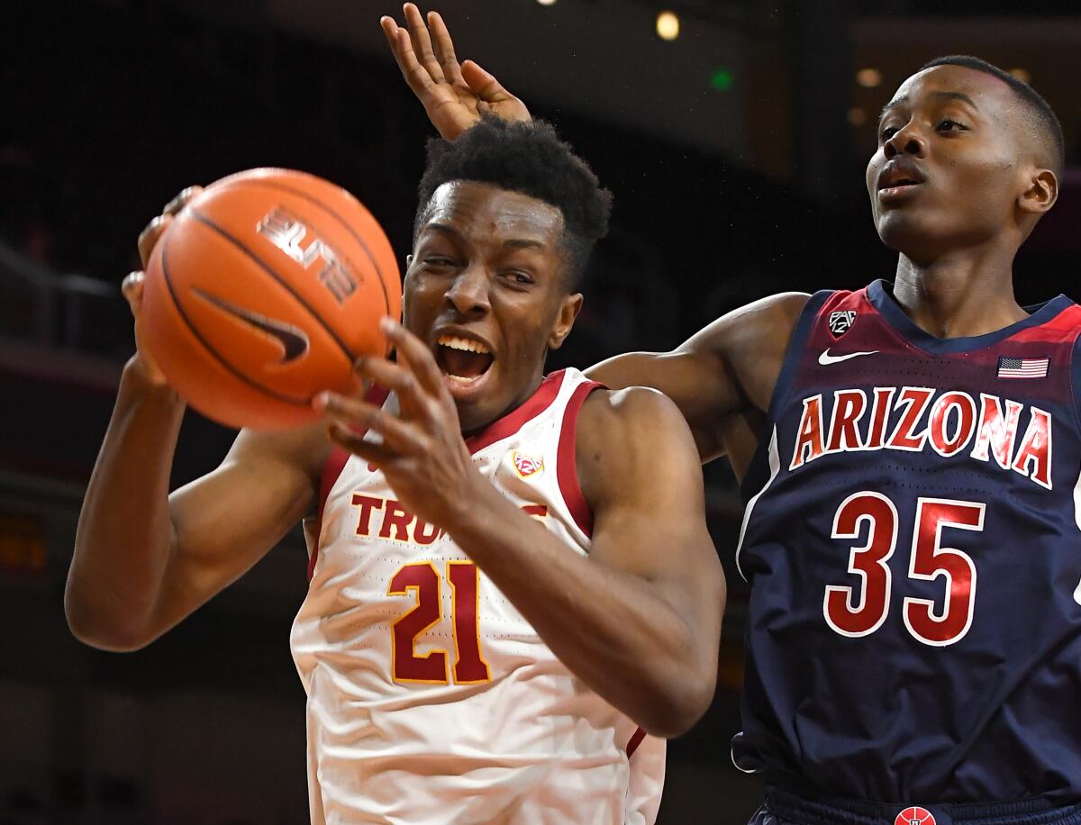 USC's Onyeka Okongwu grabs a rebound in front of Arizona's Christian Koloko during the first half of the Trojans' win at Galen Center on Thursday.