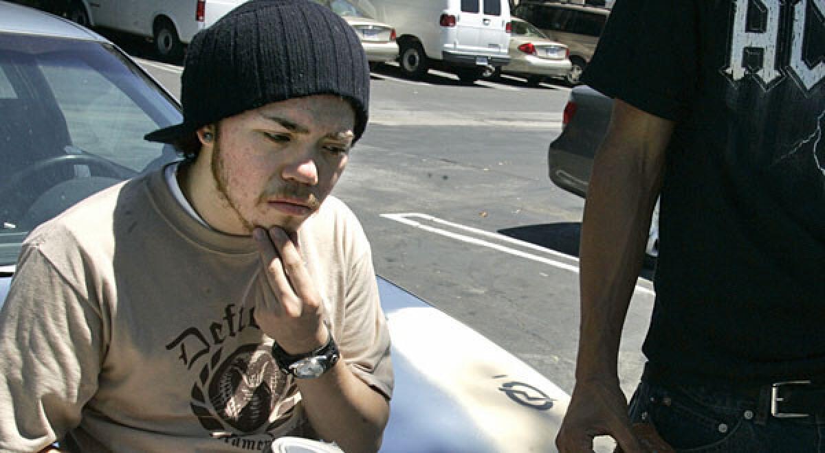 Birmingham High School dropout Elias Fuentes spends an idle moment in the parking lot of a Van Nuys restaurant.