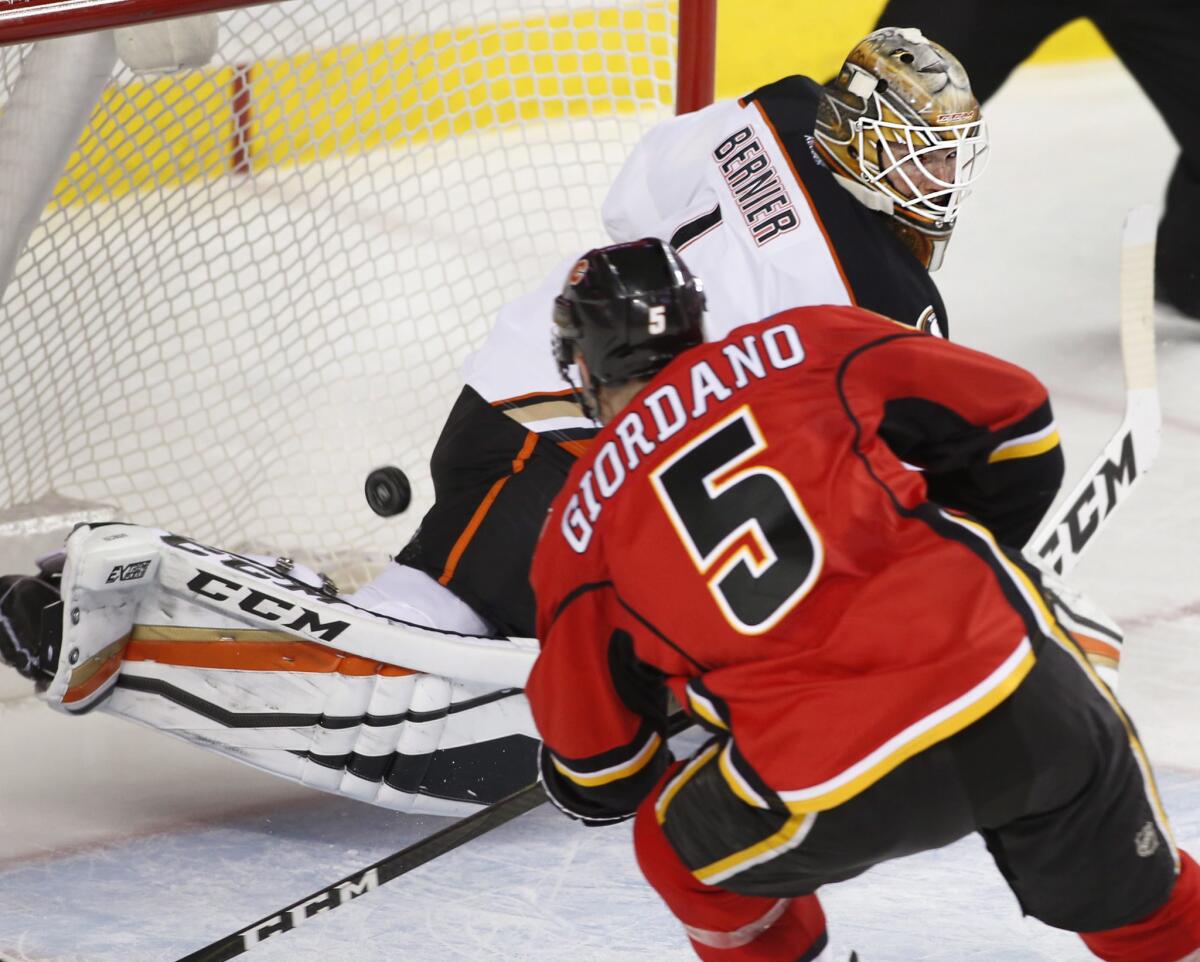 Flames' Mark Giordano, left, scores a short-handed goal against Ducks goalie Jonathan Bernier during the third period on Dec. 4.
