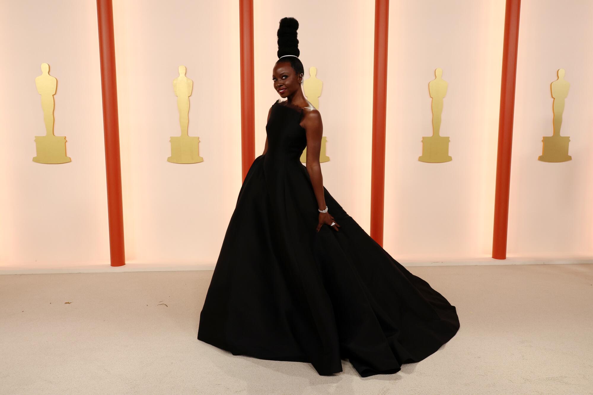 Danai Gurira in a sleeveless black gown with flowing skirt.