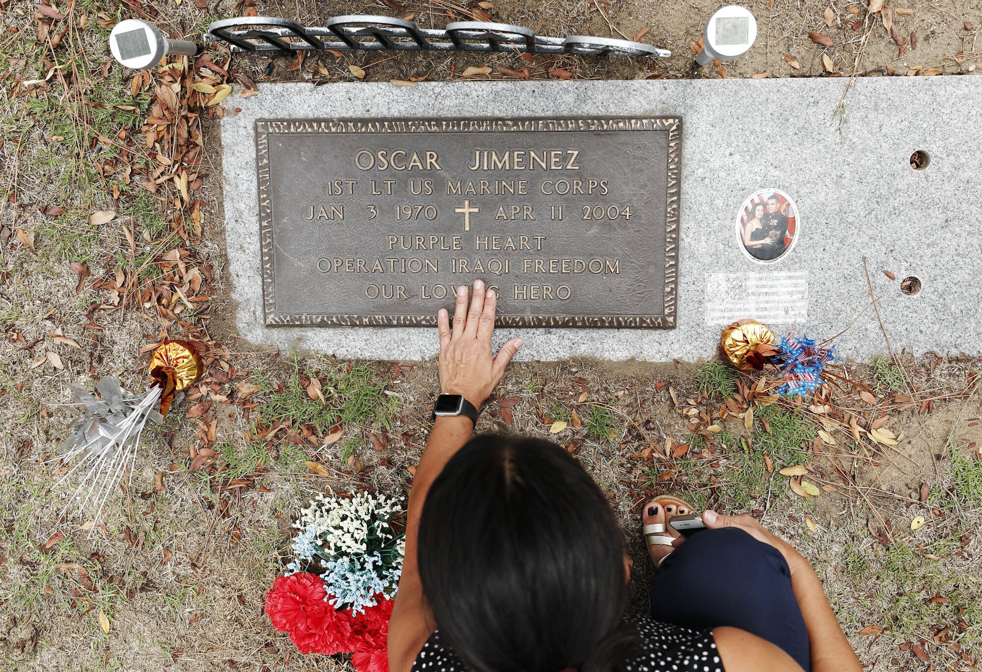 Sonia Jimenez visits the grave of her brother Oscar Jimenez at Greenwood Memorial Park in San Diego.