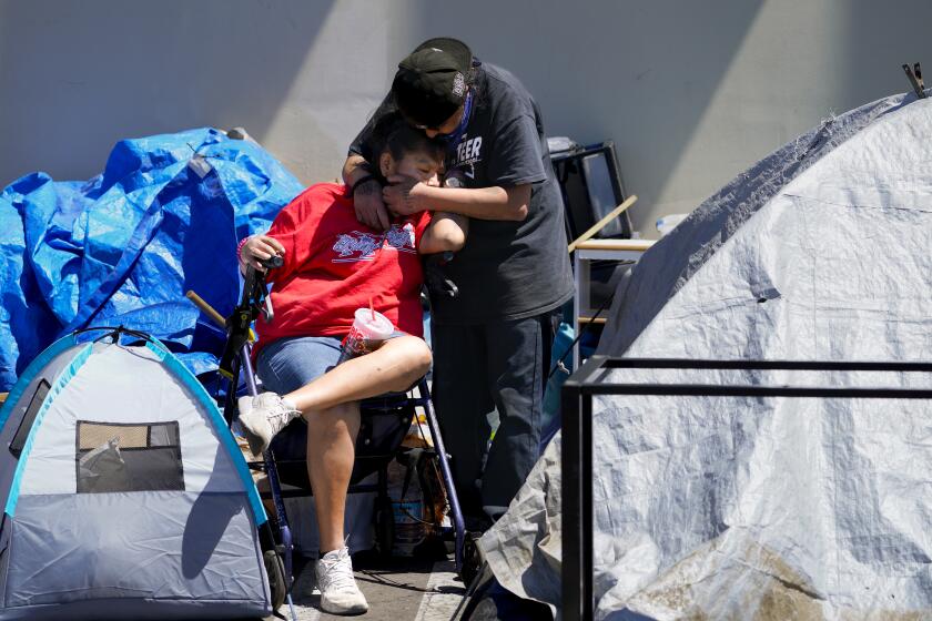 San Diego, CA, April 16: On Tuesday, April 16, 2024, at an encampment in Point Loma in San Diego, CA, a recent abatement notification was posted. Because of her spinal injury and his cancer illness, it’s a slow process for Chye Nezzie, 45, and Chino Cota to relocate their tent and personal belongings to the other side of the street. (Nelvin C. Cepeda / The San Diego Union-Tribune)