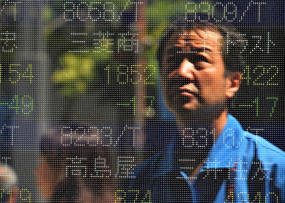 Japan's stock market has surged more than 50% in less than a year. Above, a man is reflected on a share prices board at the Tokyo Stock Exchange.