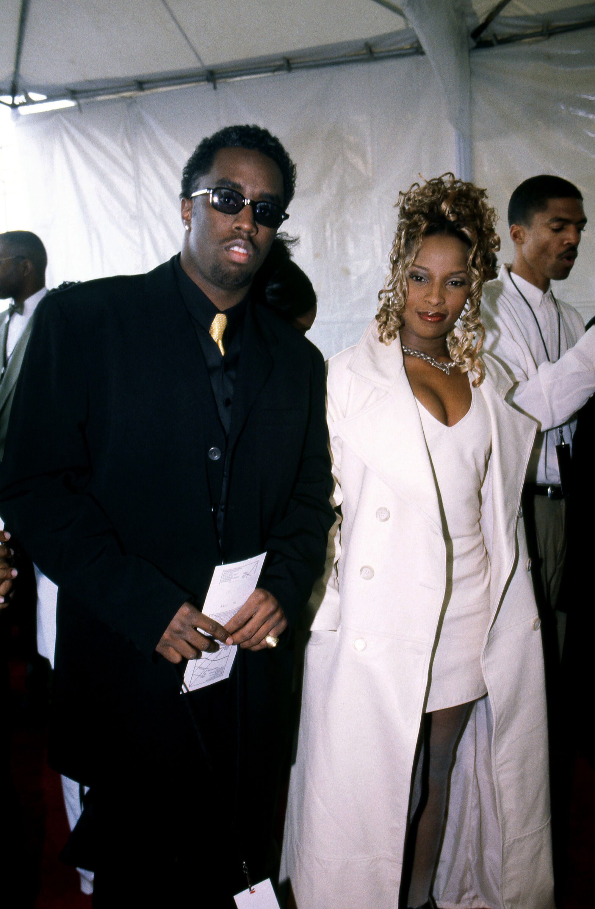 A man dressed in black walks next to a woman dressed in white.