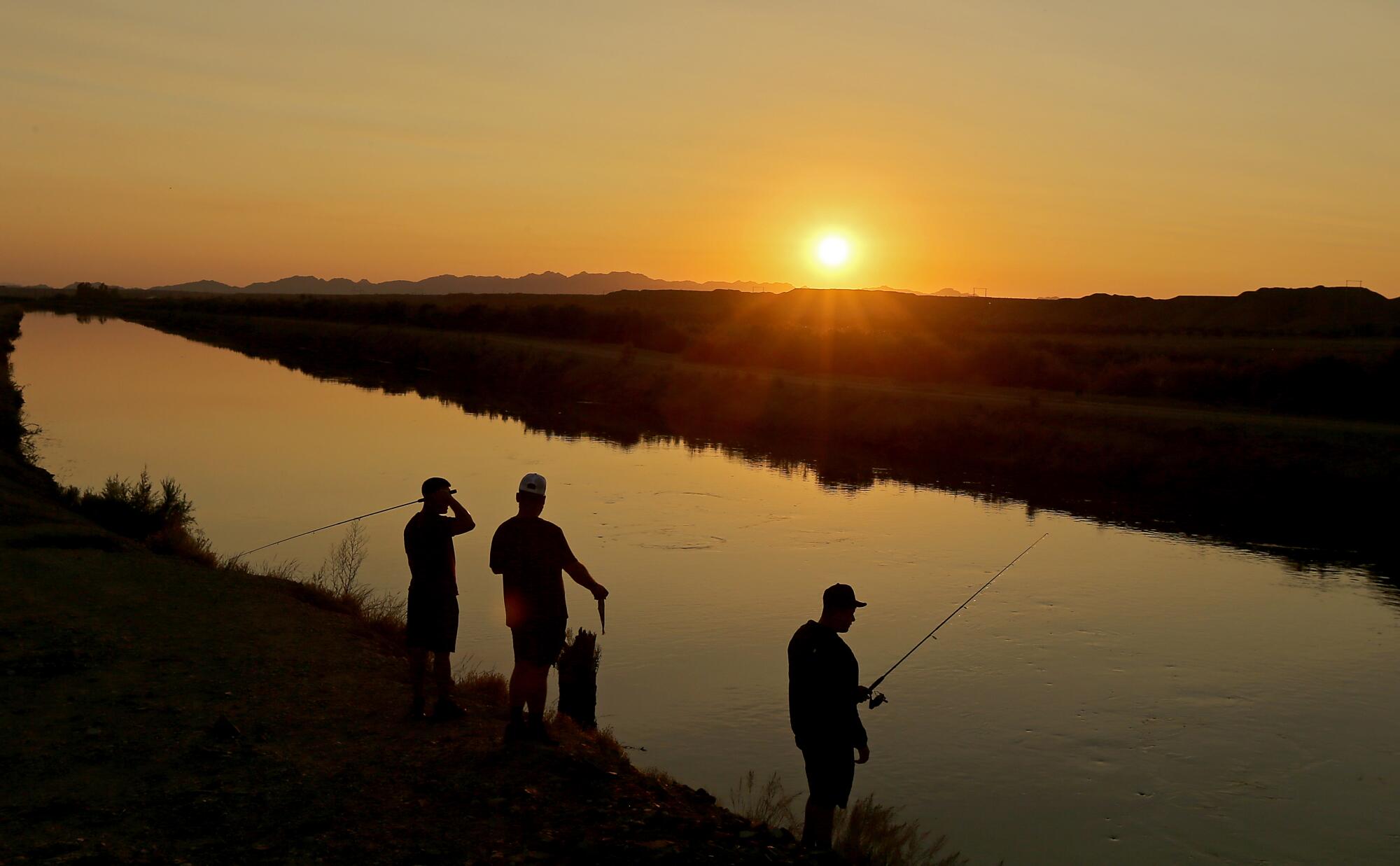 Anglers set their lines at an irrigation canal in Blythe.