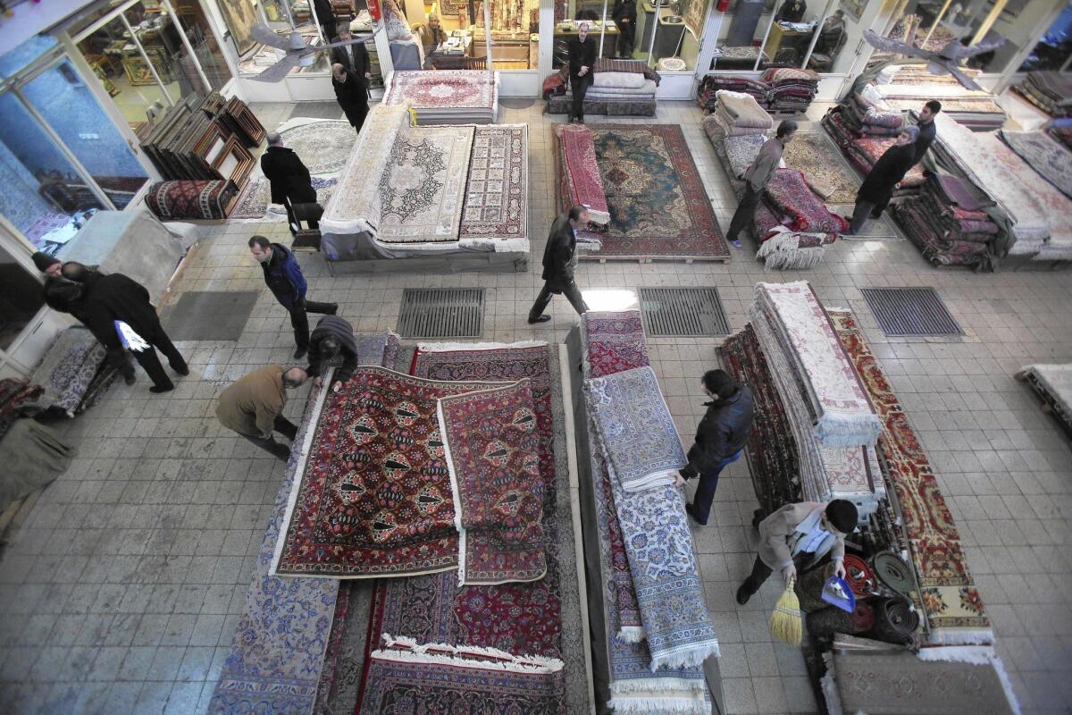 Iranian merchants and customers move among the stacks of carpets at a shop in Tehran's main bazaar. With the election last year of President Hassan Rouhani, a moderate keen to lure foreign capital, many business owners envision an Iran restored to its pre-Islamic Revolution role as a strategically situated magnet for world trade.