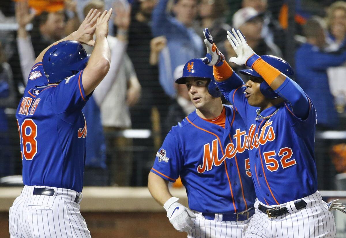 Daniel Murphy, left, celebrates with David Wright, center, and Yoenis Cespedes after scoring on Cespedes' three-run home run in the fourth inning of Game 3 of the NLDS.