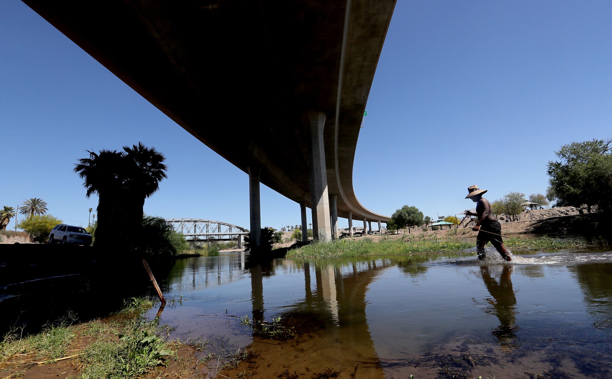 A youth wades in the Colorado River under Interstate 8 in Yuma.