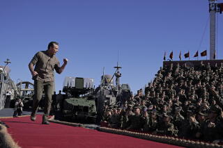 Secretary of Defense Pete Hegseth walks onto a stage