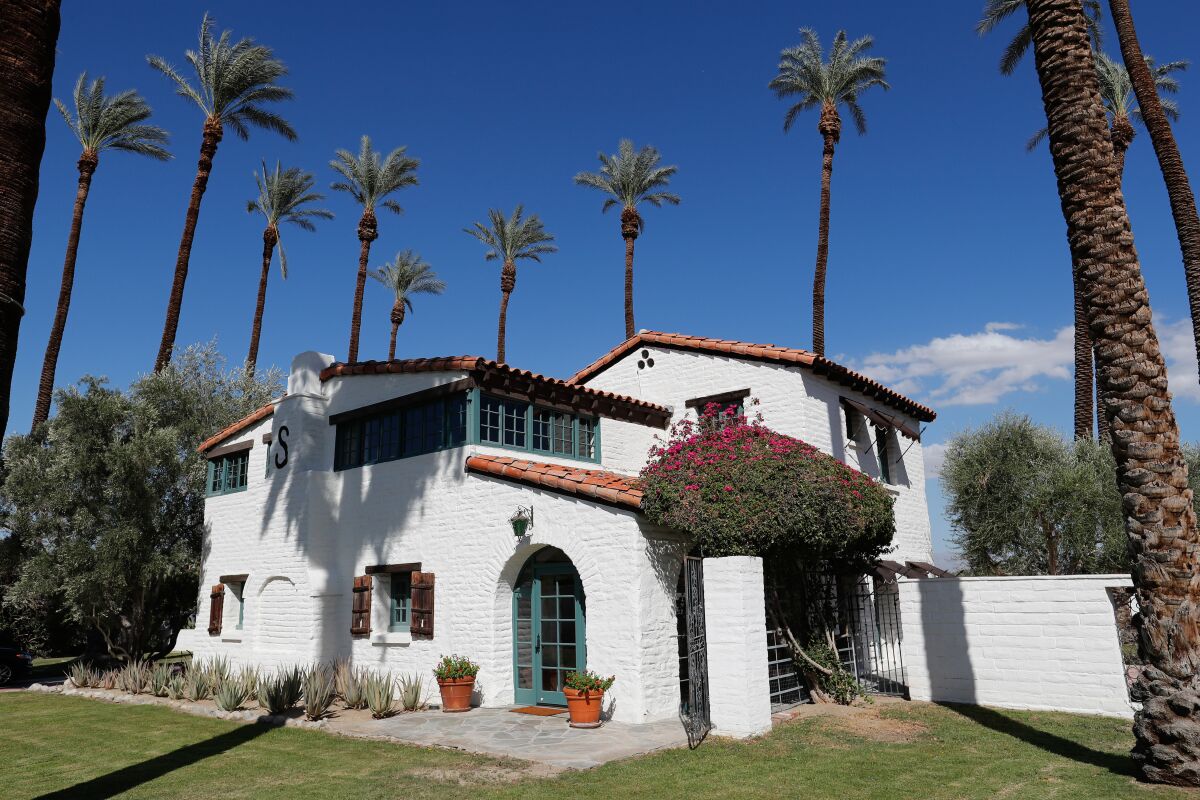 A historic white adobe house with a red tile roof.