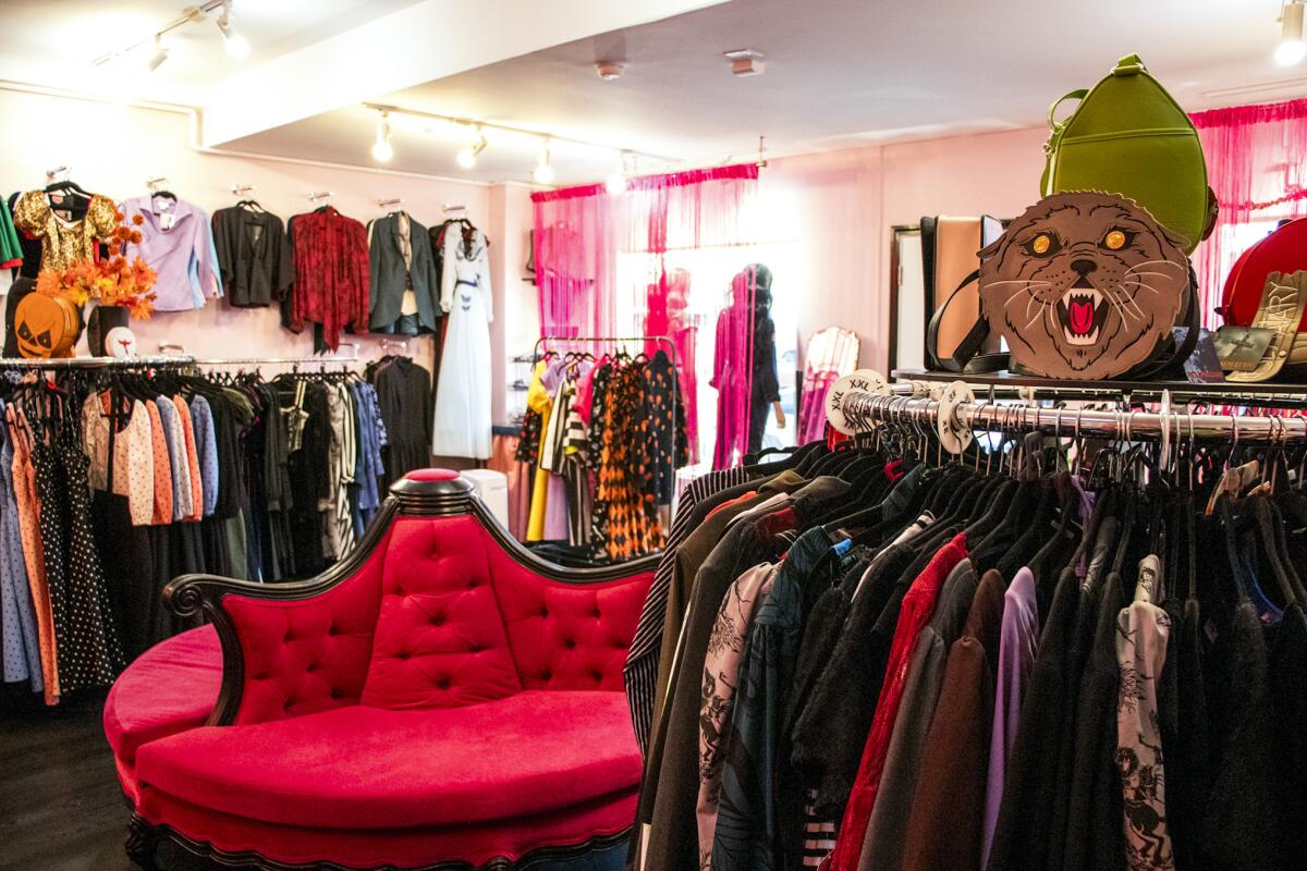 Clothing racks and circular red upholstered seating inside Vixen