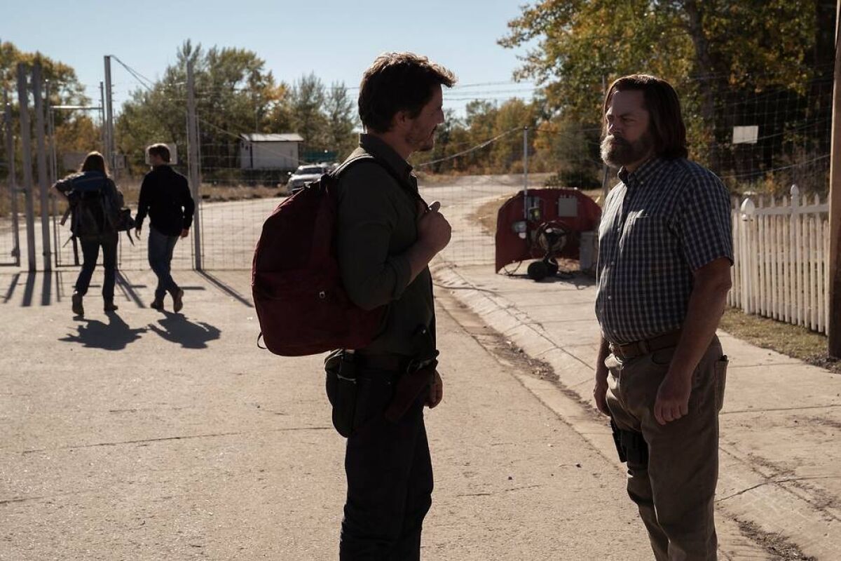 Two men talking in the street "The Last of Us." 