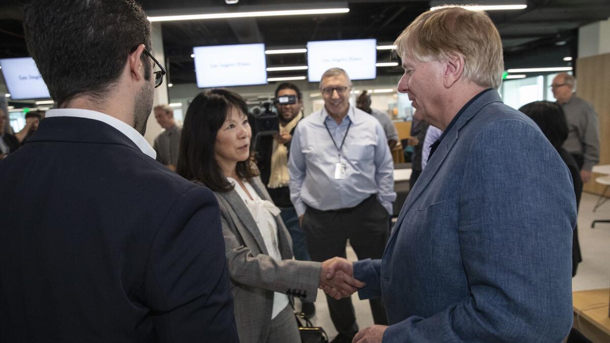 Woman shakes hands with reporters