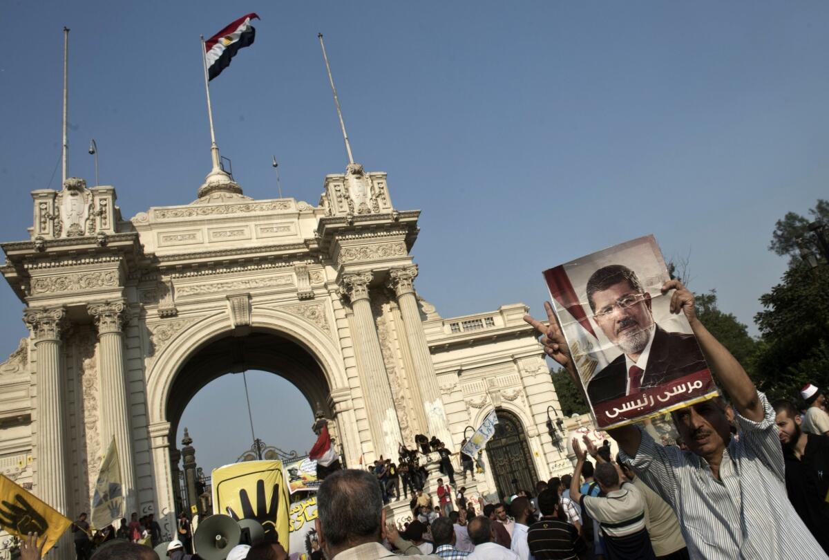 A supporter of Egypt's Muslim Brotherhood movement holds a poster of ousted President Mohamed Morsi at a rally outside the presidential palace in Cairo.