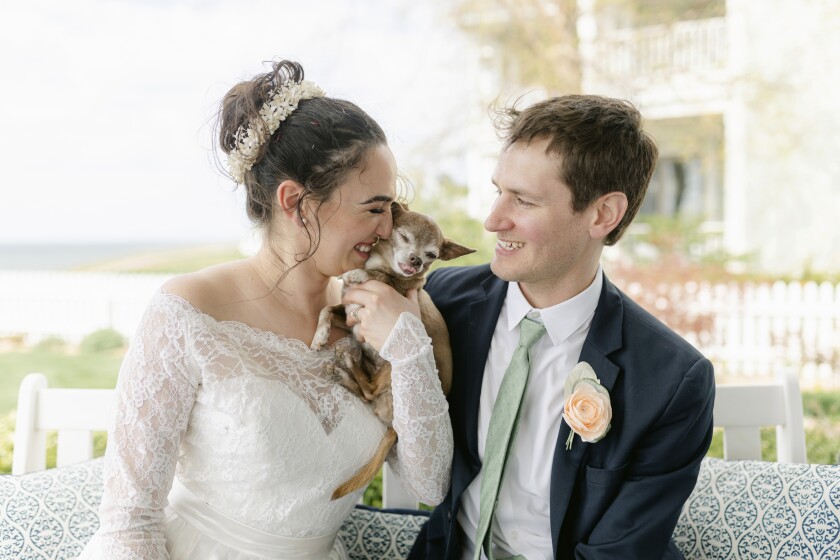 Caitlin Koska, left, and Michael White appear with their 14-year-old rescue dog, Luna, at their wedding on May 1, 2021, in St. Joseph, Mich. The couple adopted their pet after her owner died through Tyson’s Place Animal Rescue, a specialized organization focused on helping the terminally ill and seniors headed to residential care. (Cat Carty Buswell via AP)