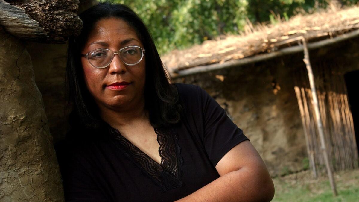 Marilyn Vann, whose family is black with Cherokee blood, poses in a re-creation of a Cherokee village at the Cherokee National Museum in Tahlequah, Okla. The Cherokee Nation is denying her citizenship.