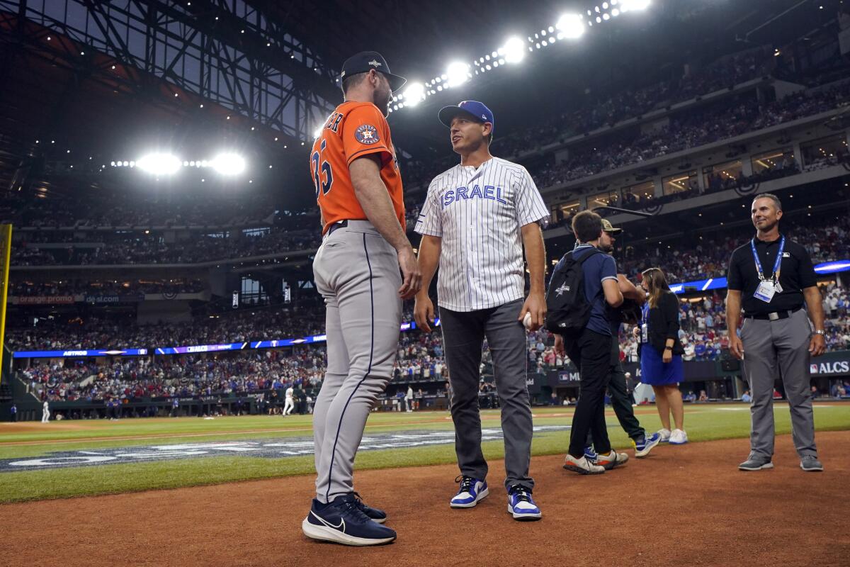 Rangers executive Ian Kinsler, right, wearing an Israel national team jersey, talks with Astros pitcher Justin Verlander