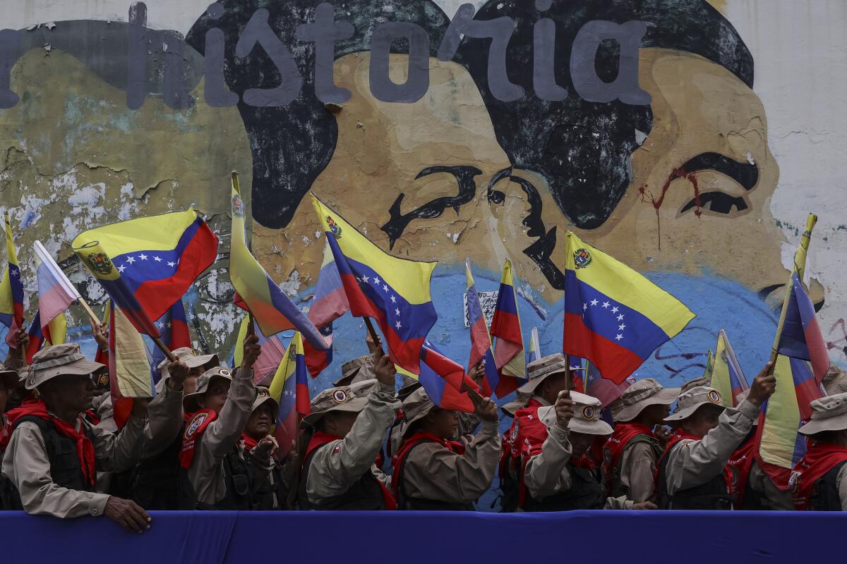Members of the Bolivarian militia wave Venezuelan flags in Caracas on Wednesday.