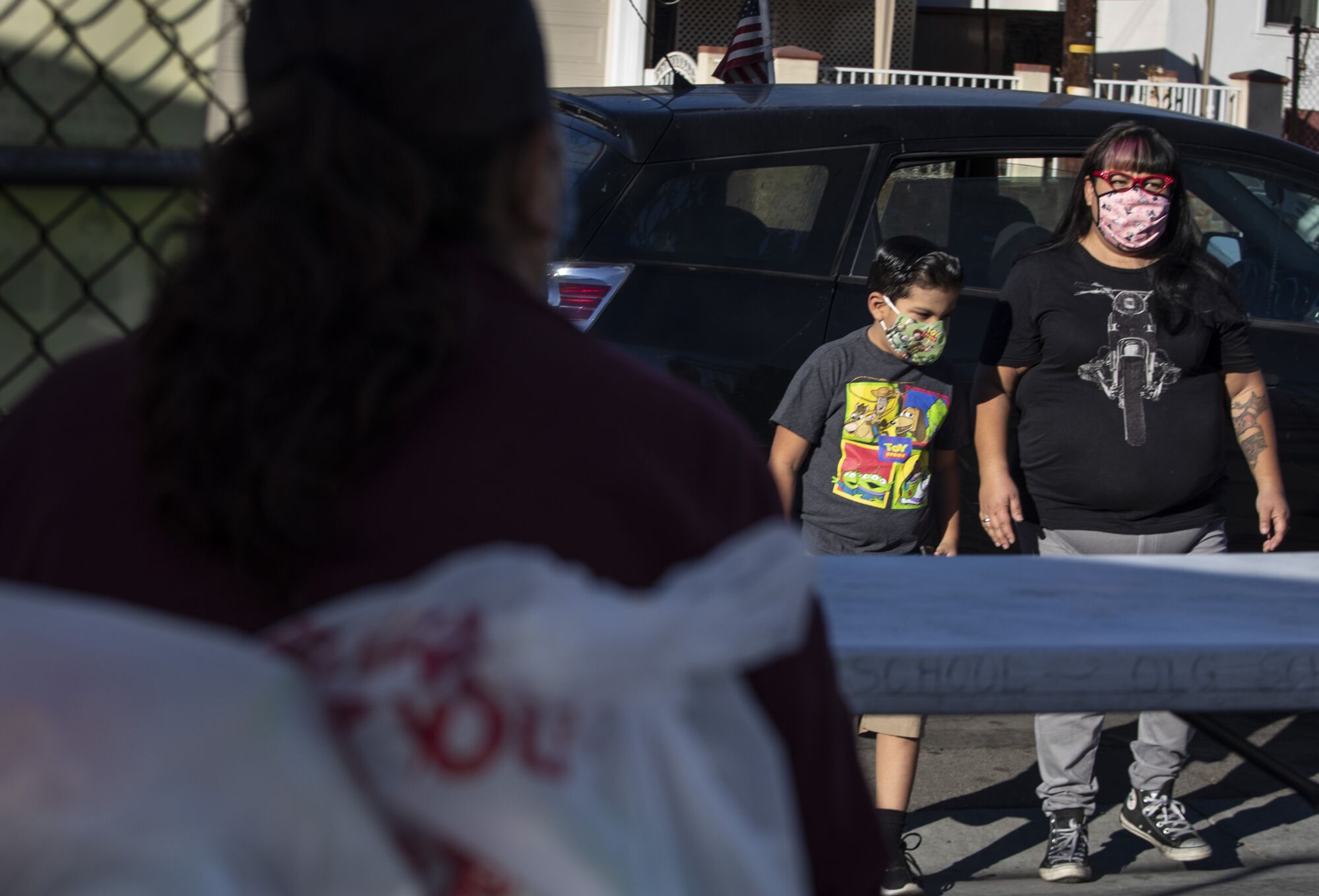 Paloma Yanez and her son, Benny Jr., pick up bags of groceries from a food pantry in East Los Angeles.