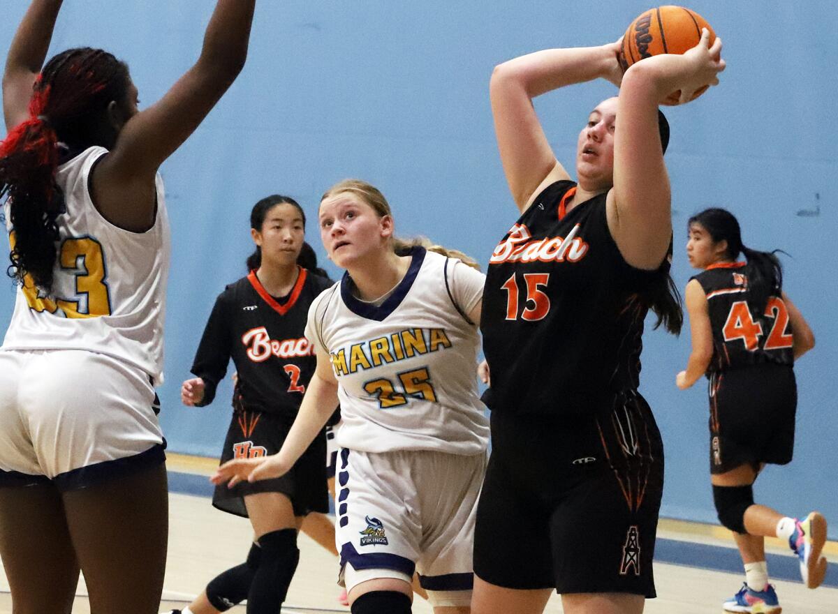 Huntington Beach's Melanie Rose (15) looks to pass over Marina's Rylee Bradley (23) during a Wave League game on Monday.