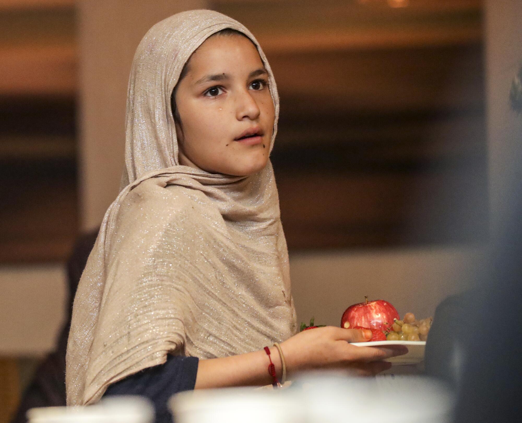 A child holds a plate of food.