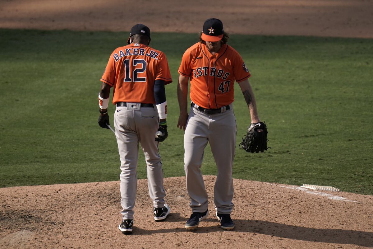 Houston Astros relief pitcher Chris Devenski, right, is relieved by manager Dusty Baker during the eighth inning of a baseball game against the Los Angeles Angels, Sunday, Sept. 6, 2020, in Anaheim, Calif. (AP Photo/Jae C. Hong)