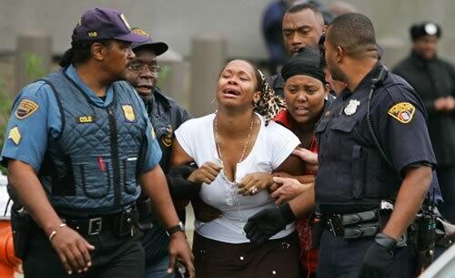 A woman is escorted from SuccessTech Academy in Cleveland after two teachers and two students were wounded by a 14-year-old gunman who police said then killed himself. The shooter was identified as Asa H. Coon, a 14-year-old who was suspended for fighting two days earlier. Authorities said Coon, armed with two revolvers, fired eight shots as he moved through the converted five-story office building.