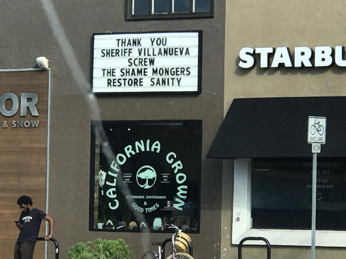 A marquee outside a shop reads, 'Thank you, Sheriff Villanueva. Screw the Shame Mongers.'