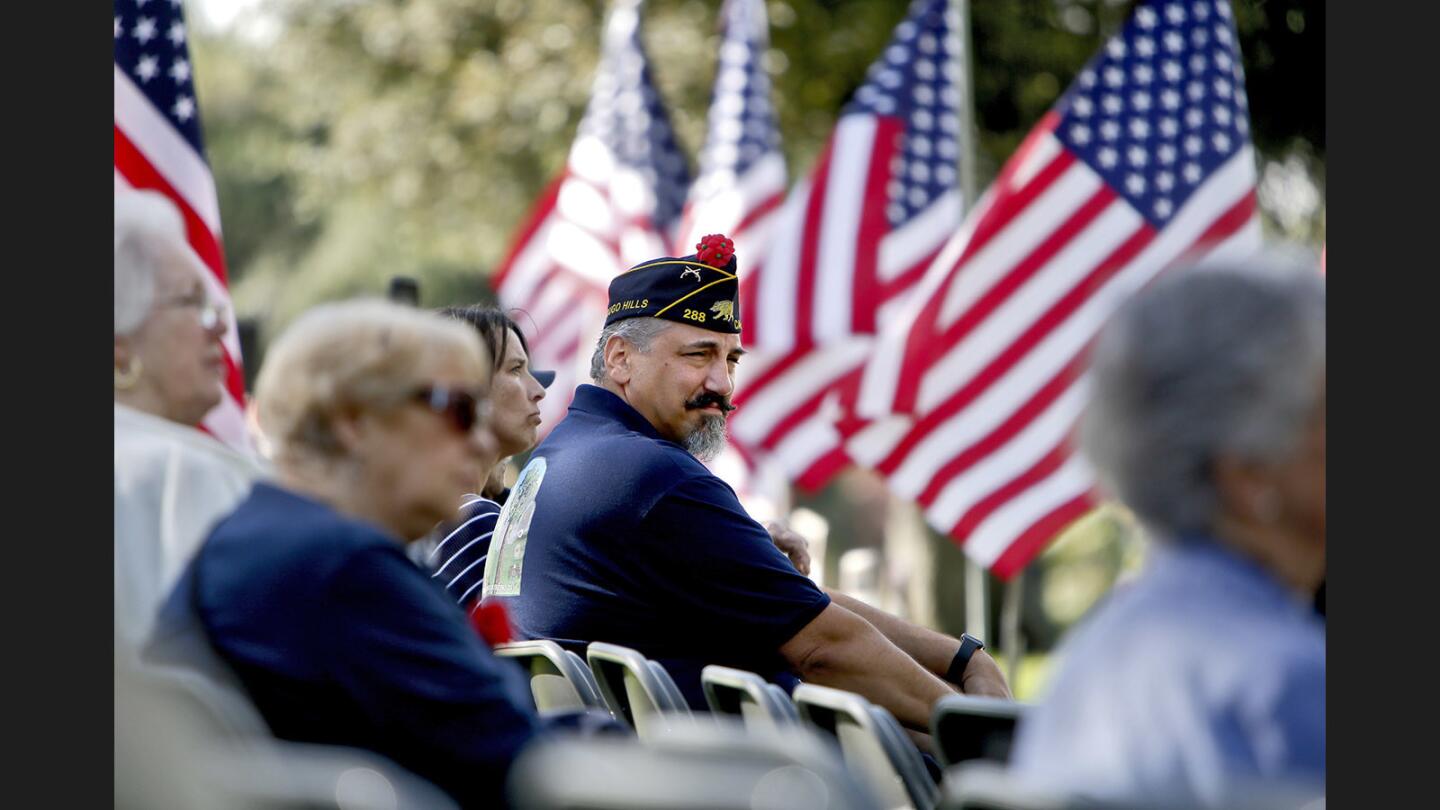 American Legion Post 288 member Robert Wollenweber, US Army, listens speakers as flags wave in the wind at the Memorial Day Service at Two Strike Park Memorial Wall, in La Crescenta on Monday, May 29, 2017. The event was presented by the American Legion Post 288 and the VFW Post 1614.
