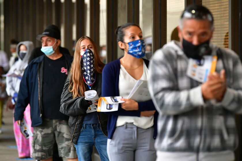 TOPSHOT - Voters wear face-coverings while waiting in line to vote for the 2020 US elections at the Los Angeles County Registrar in Norwalk, California on November 3, 2020. - The United States started voting Tuesday in an election amounting to a referendum on Donald Trump's uniquely brash and bruising presidency, which Democratic opponent and frontrunner Joe Biden urged Americans to end to restore "our democracy." (Photo by Frederic J. BROWN / AFP) (Photo by FREDERIC J. BROWN/AFP via Getty Images)