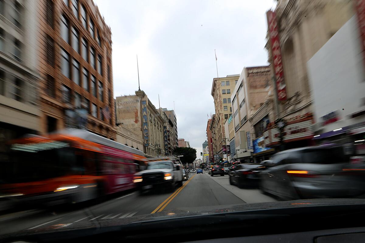 Old buildings line a busy street in downtown Los Angeles.