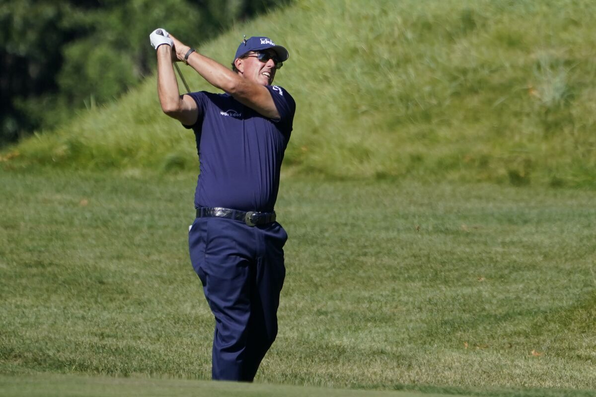FILE - In this Aug. 20, 2020, file photo, Phil Mickelson hits from the rough on the 14th fairway in the first round of the Northern Trust golf tournament at TPC Boston in Norton, Mass. Mickelson will begin his preparation for the Masters in earnest on Friday, Oct. 16, 2020, at a place, and on a tour, not typically associated with the regimen required to win a major. The lefthander is making his second start on the PGA Tour Champions in the Dominion Energy Charity Classic at the Country Club of Virginia's somewhat forgiving James River course. (AP Photo/Charles Krupa, File)
