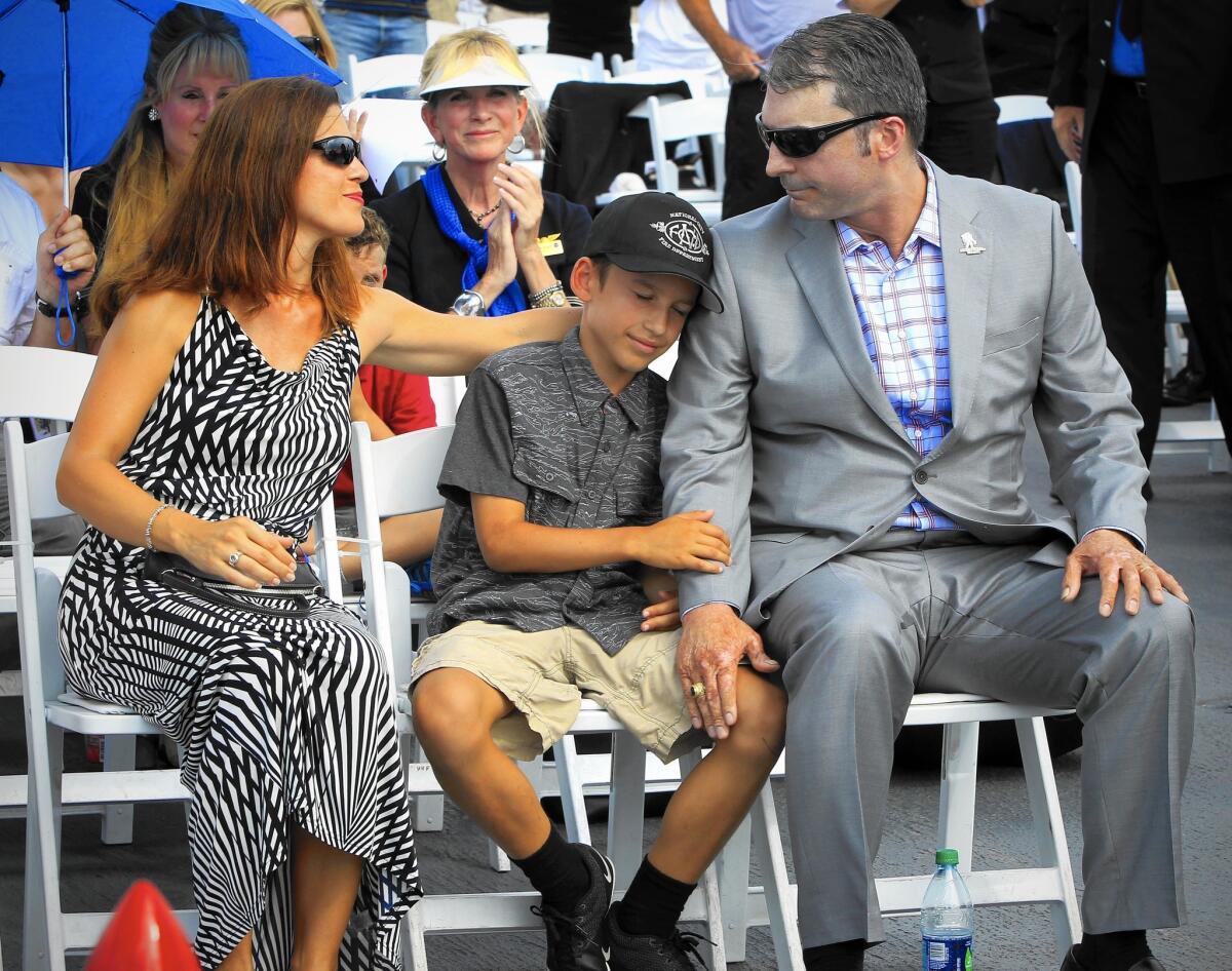 Retired Navy Lt. Kevin Shaeffer, severely injured during the 9/11 attack on the Pentagon, sits with his wife, Blanca, and son Steven after speaking during a ceremony at the USS Midway Museum in San Diego.