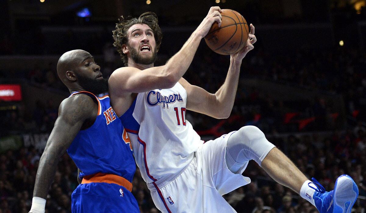 Clippers center Spencer Hawes pulls down a rebound against Knicks forward Quincy Acy in the second half of their game on Wednesday night.