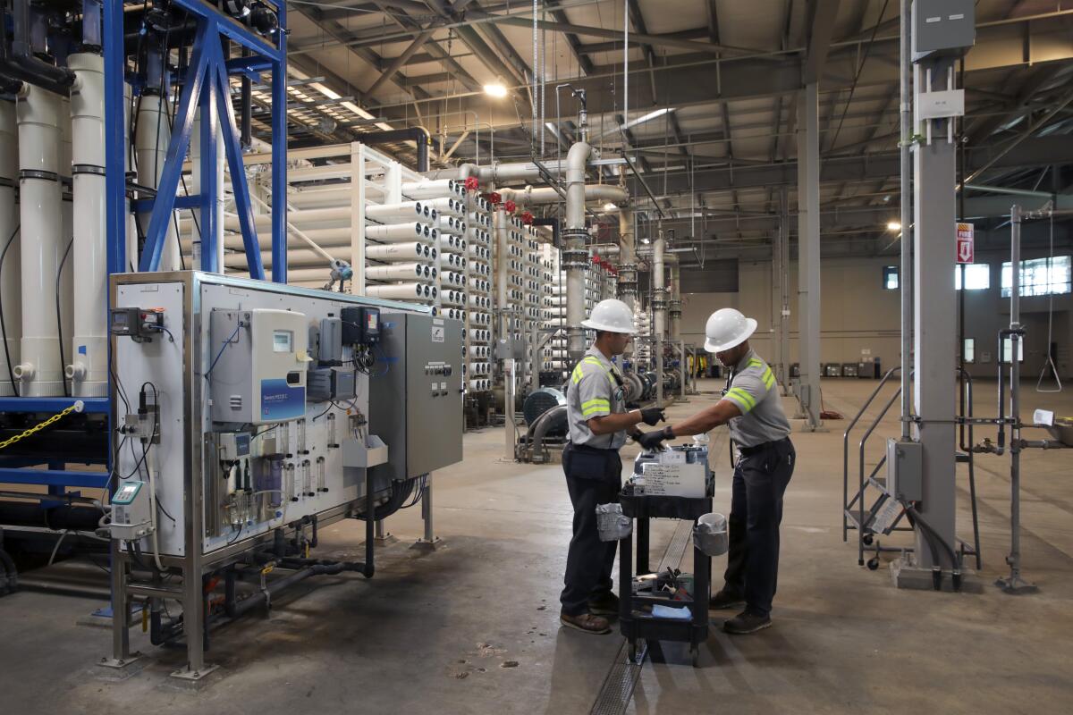 Two workers at a water filtration plant.
