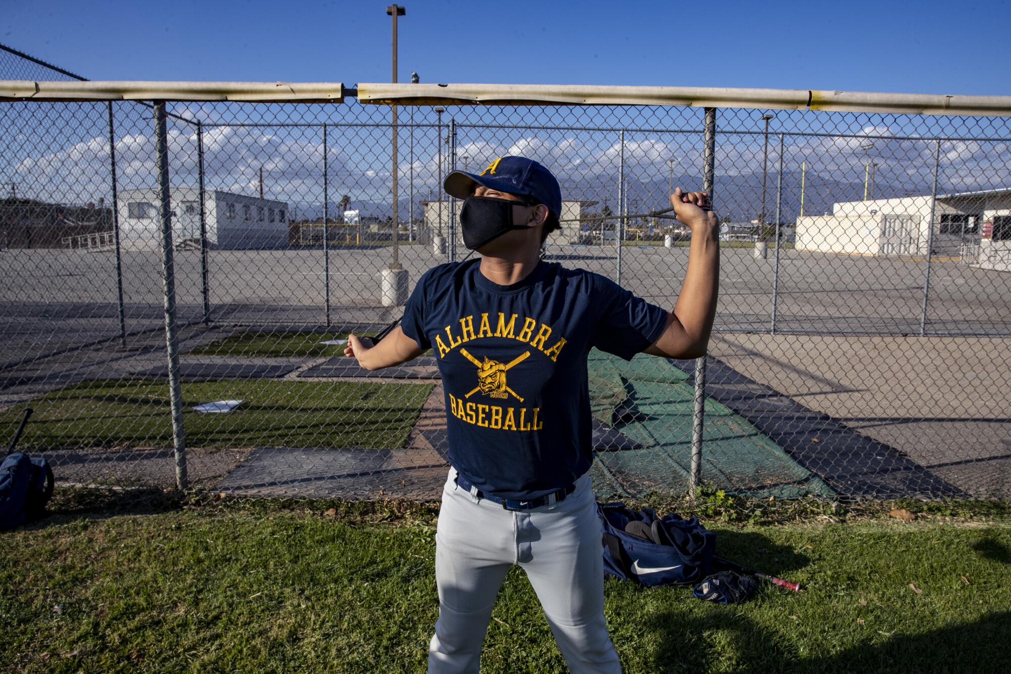 A baseball player stretches with resistance bands