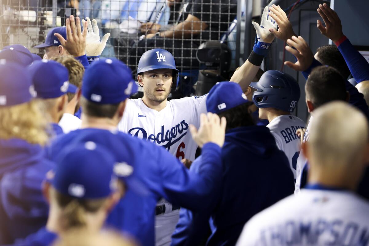 Dodgers shortstop Trea Turner celebrates with his teammates in the dugout after hitting a solo home run.