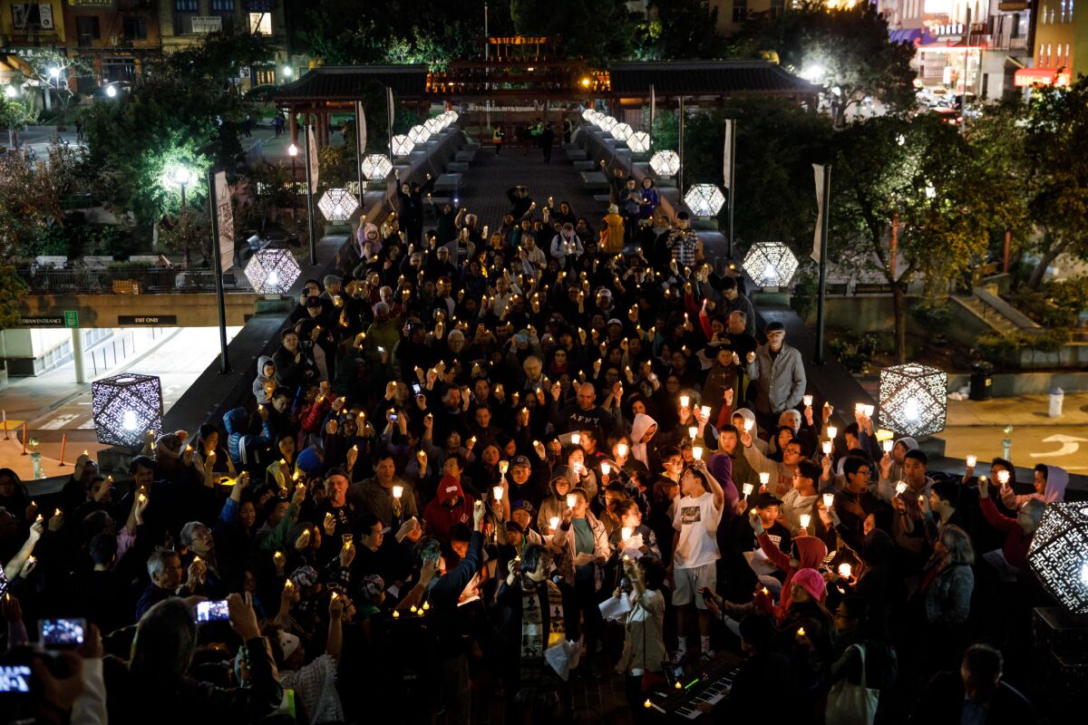 Community members sing and hold a candle light vigil during the “Light Up The Night” rally in San Francisco, Calif.