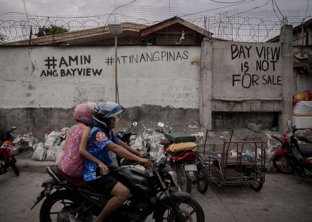 “Bayview is ours,” and “The Philippines is ours” are written on a wall along Bayview Drive in Paranaque City, where Chinese businesses have taken over.