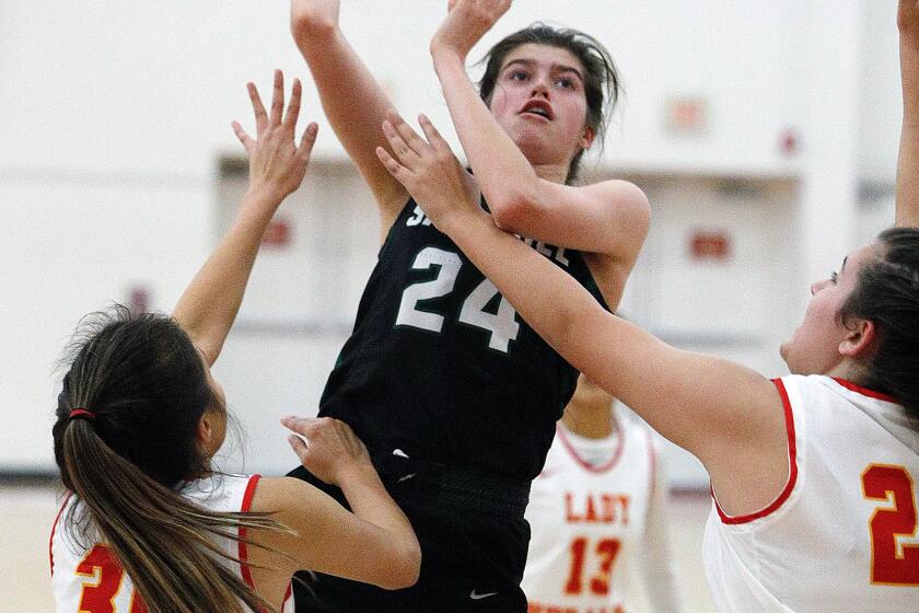 Sage Hill's Isabel Gomez runs and shoots in the paint against Whittier Christian's Juliette Corona and Haley Gainer in a nonleague girls' basketball game at Whittier Christian on Thursday, December 12, 2019.