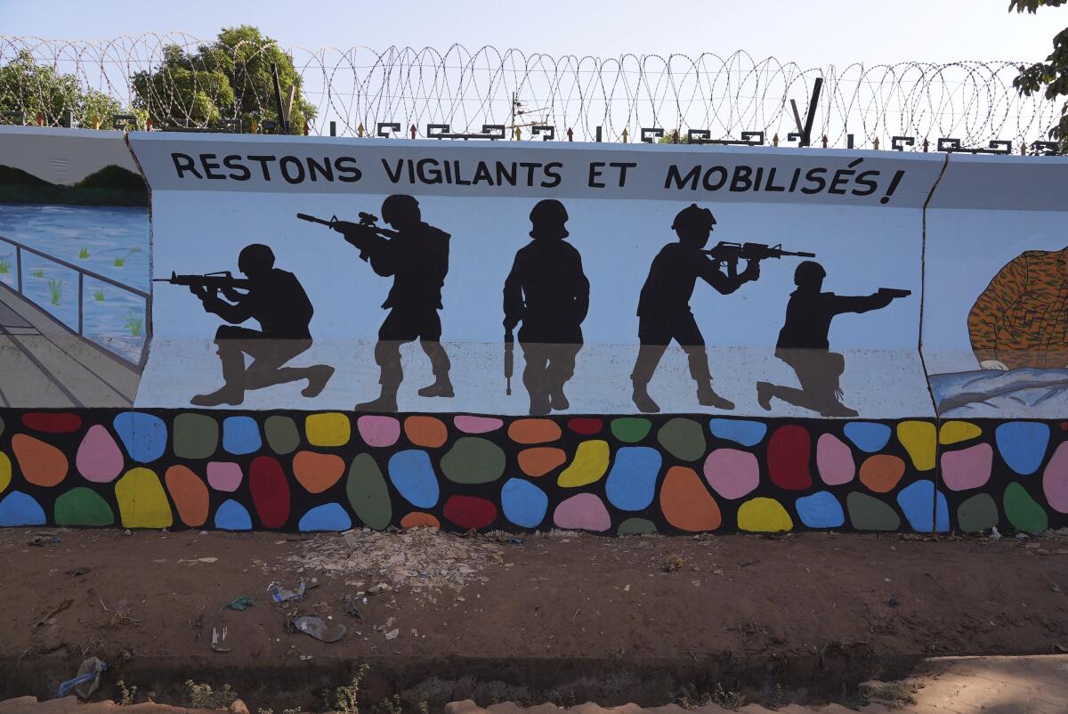 A mural shows the silhouettes of soldiers pointing guns.
