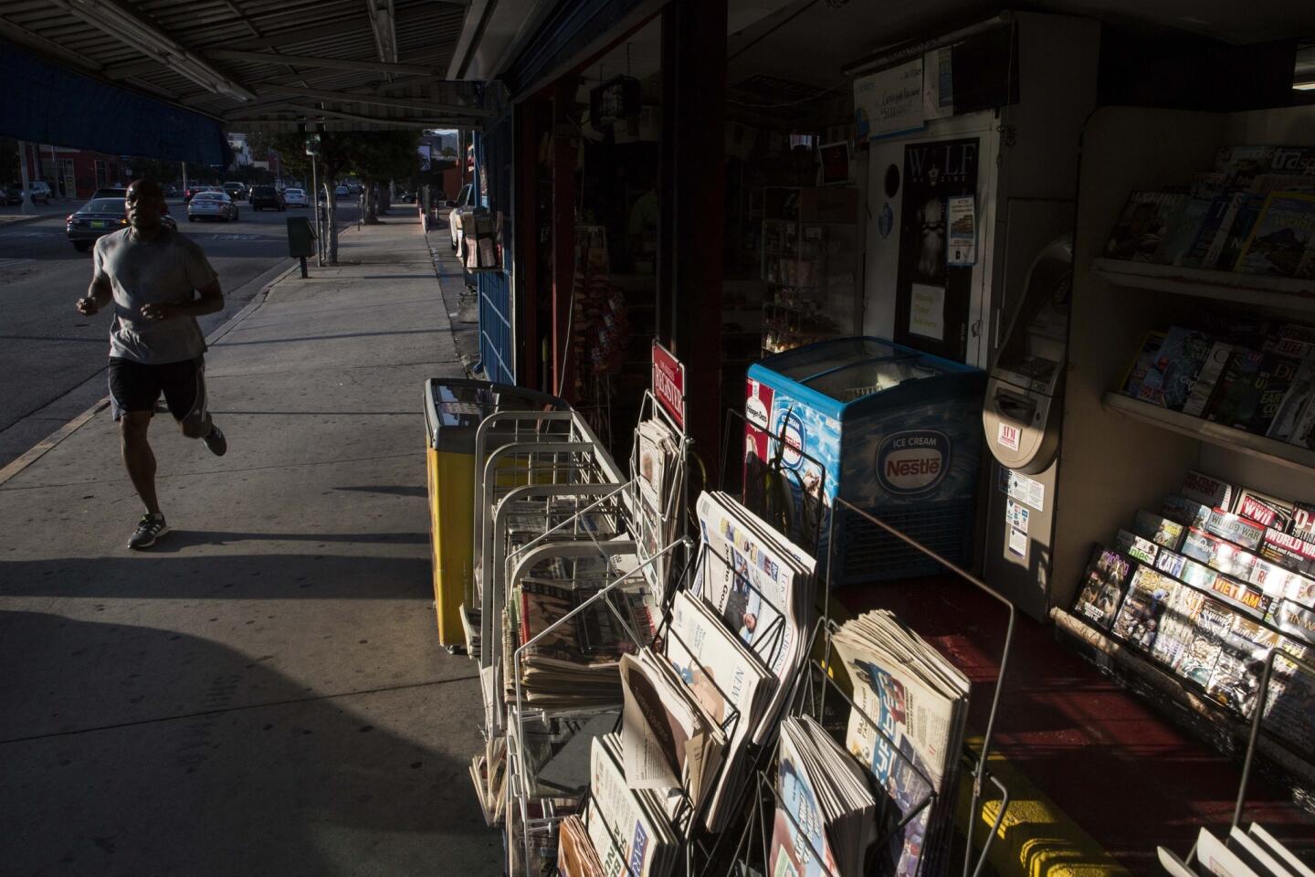 A man jogs past Centerfold International Newsstand on Fairfax Avenue in Los Angeles. With several out-of-state newspapers and more than 400 magazines to choose from, including four about wristwatches, Centerfold has managed to survive in a city full of shuttered newsstands.