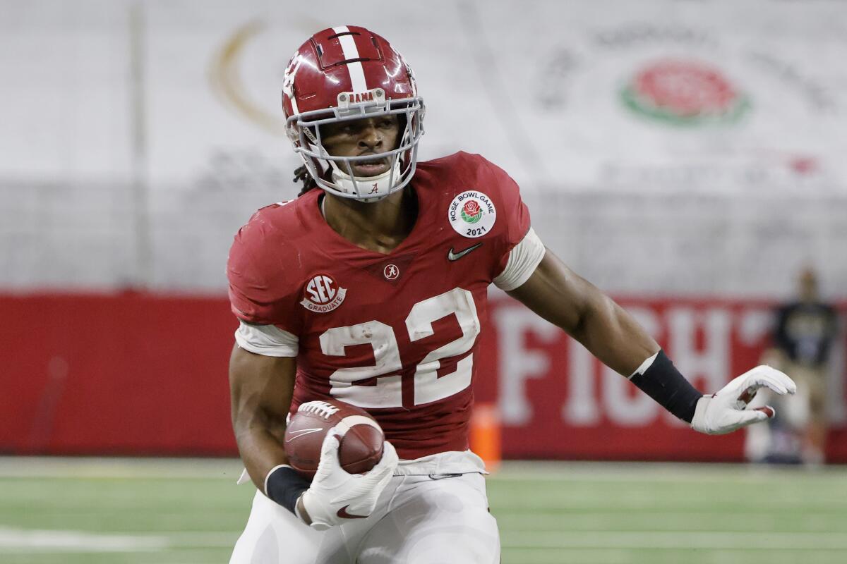 Former Alabama running back Najee Harris carries the ball during a game.