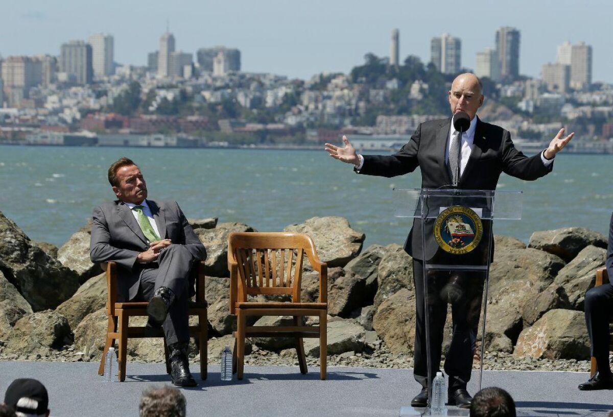 Then-Gov. Jerry Brown, with former Gov. Schwarzenegger, speaks at a July 2017 signing ceremony in San Francisco for a bill to reduce climate change.